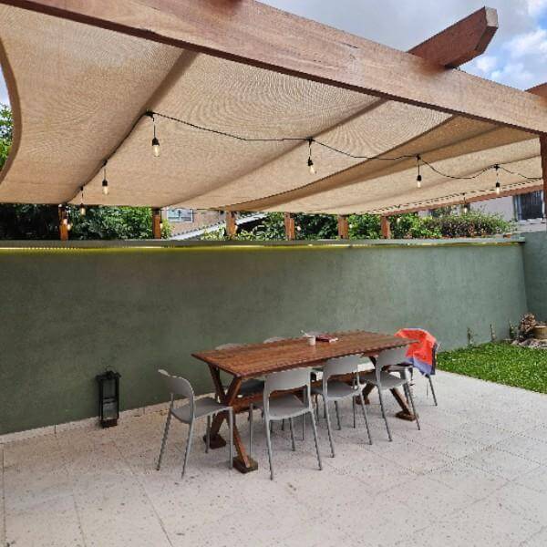 Vela de sombra Coolaroo sobre terraza y jardín